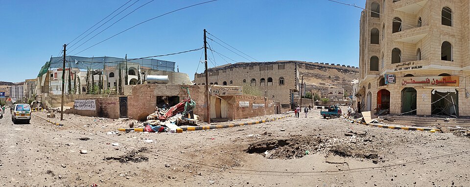 Fotografia: Ibrahem Qasim (2015). Widespread destruction in the residential neighborhoods near mountain Attan following airstrikes. Wikimedia Commons. Licença CC BY-SA 4.0. Imagem recortada para adaptação ao formato da publicação.
